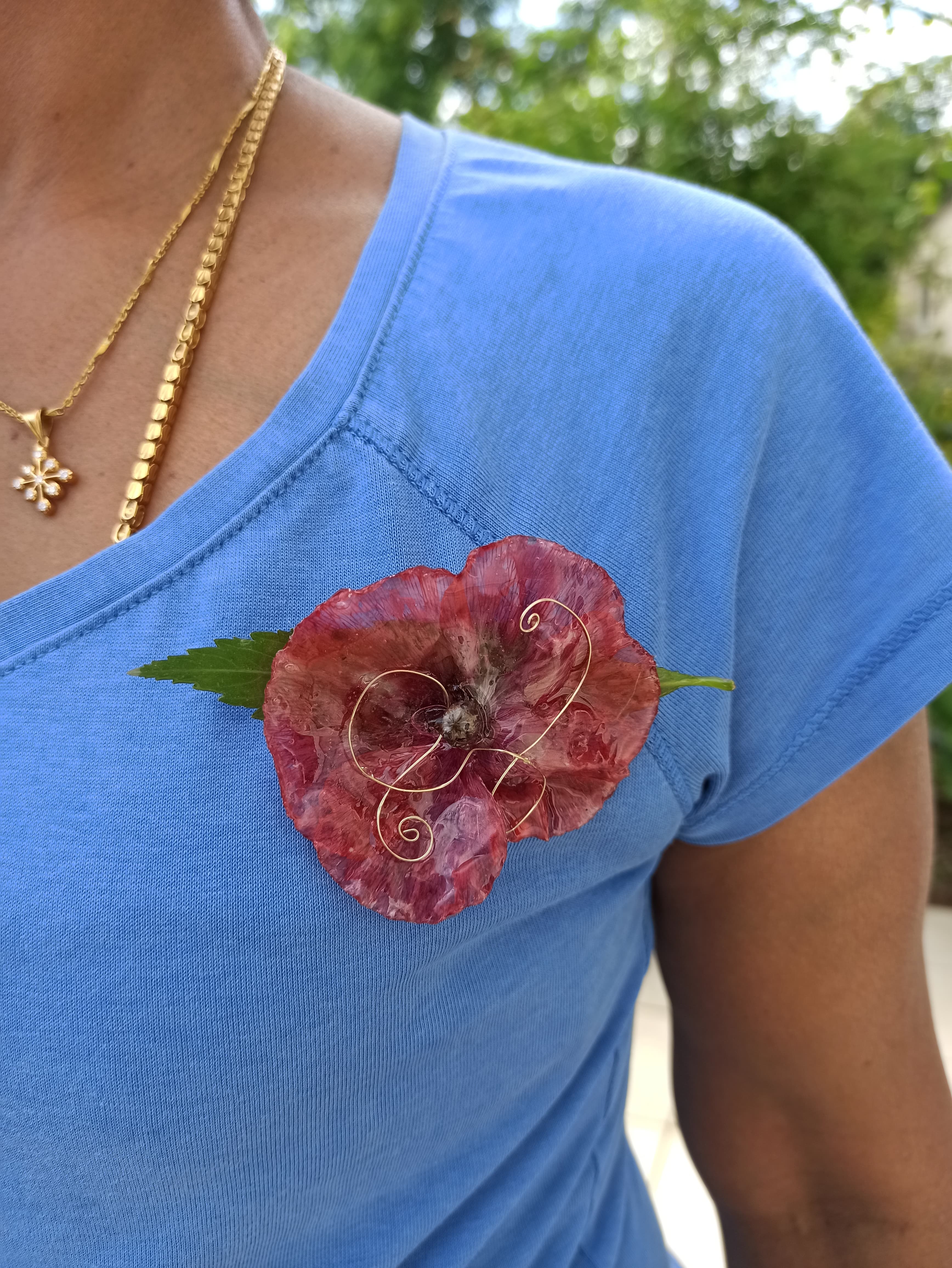 Broche en coquelicot naturel portée sur un t-shirt